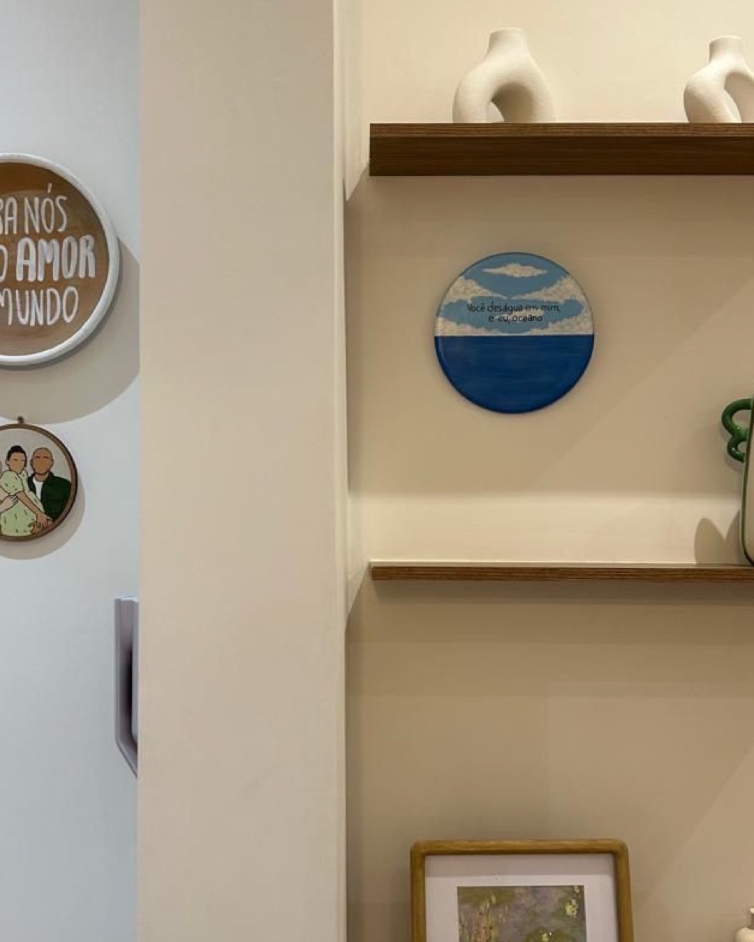 Detalhe de estante com nichos de madeira, peças decorativas e parede off-white